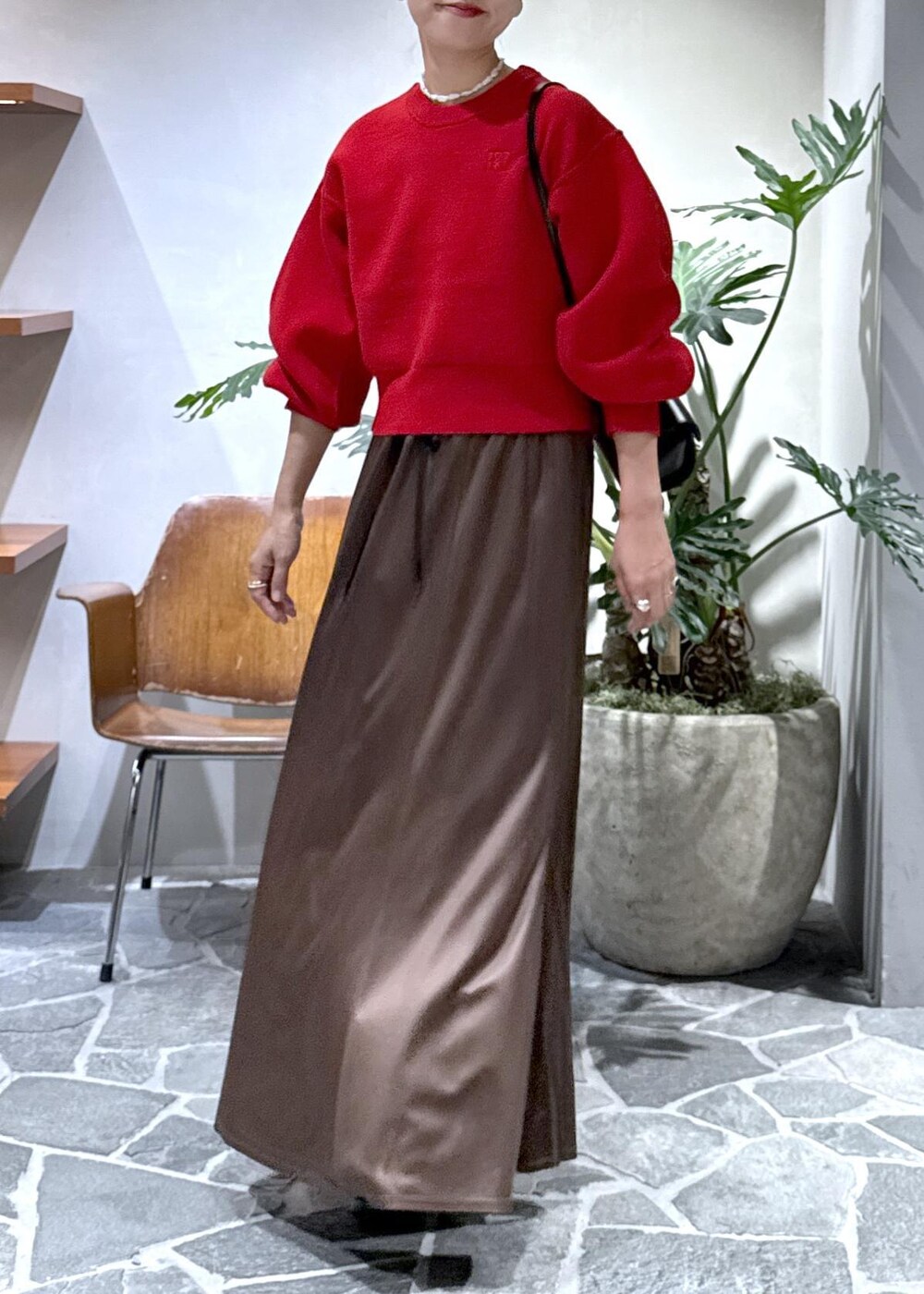 ブラック系のブーツ、ブラウン系のスカート、レッド系のニット/セーターを着用したレディースの秋コーディネートの5枚目の写真