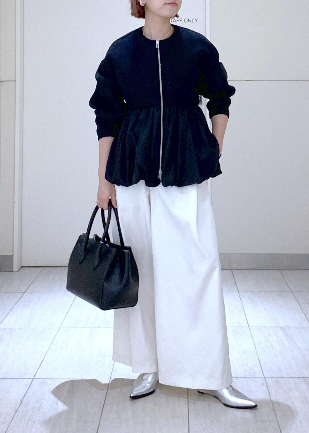 ホワイト系のその他パンツ、ブラック系のカーディガン/ボレロ、シルバー系のパンプスを着用したレディースの冬コーディネートの2枚目の写真