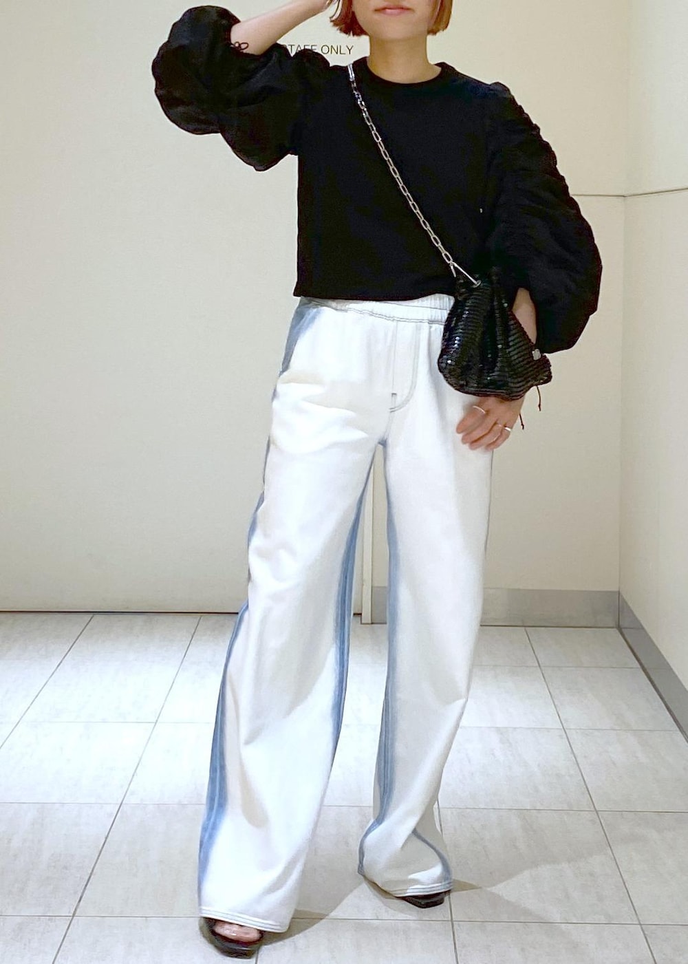 ブラック系のサンダル、ブラック系のTシャツ/カットソー、ブラック系のハンドバッグを着用したレディースの春コーディネートの3枚目の写真