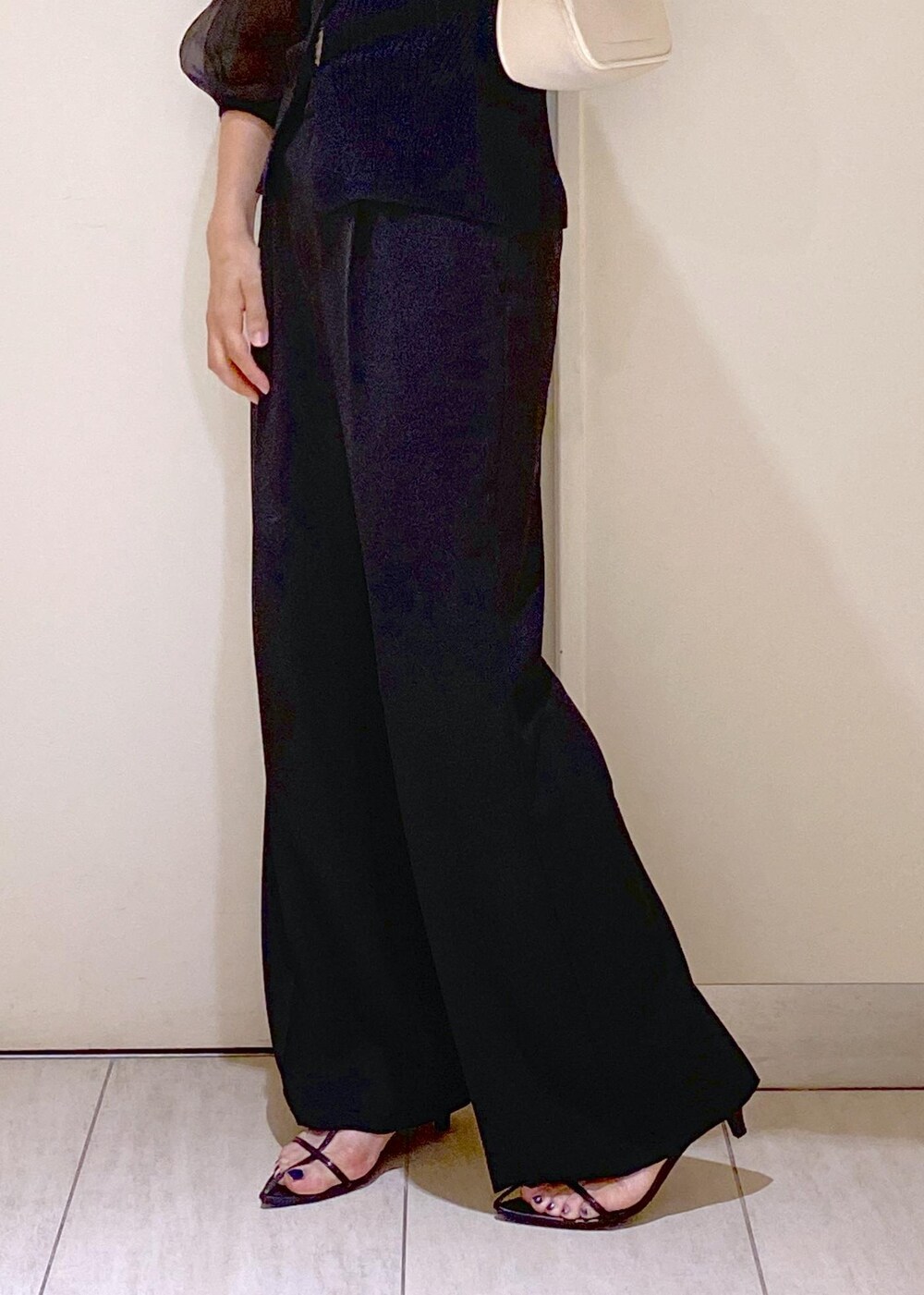 ブラック系のサンダル、ホワイト系のショルダーバッグ、ブラック系のスラックスを着用したレディースの夏コーディネートの8枚目の写真