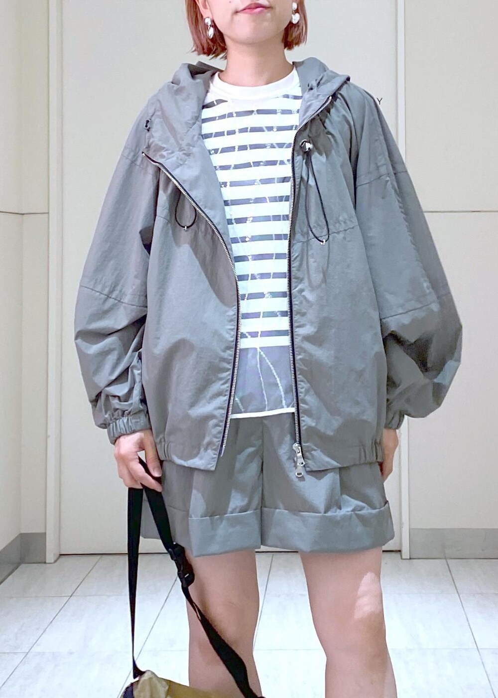 ホワイト系のニット/セーター、ベージュ系のボディバッグ/ウエストポーチ、グリーン系のその他アウターを着用したレディースの夏コーディネートの8枚目の写真