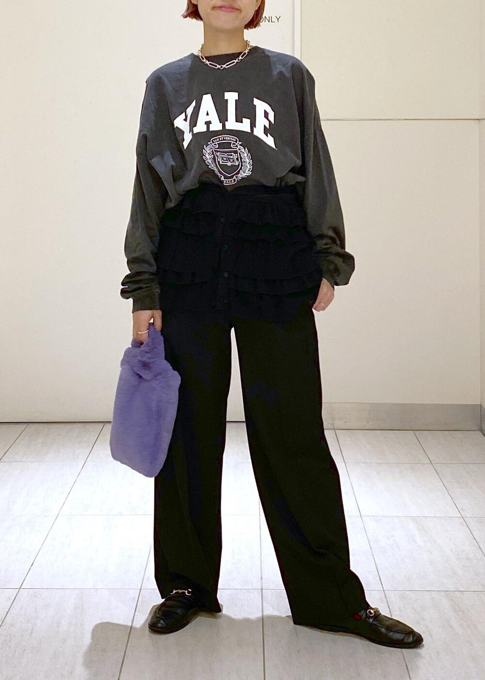 ブラック系のローファー、パープル系のトートバッグ、シルバー系のネックレスを着用したレディースの冬コーディネートの2枚目の写真