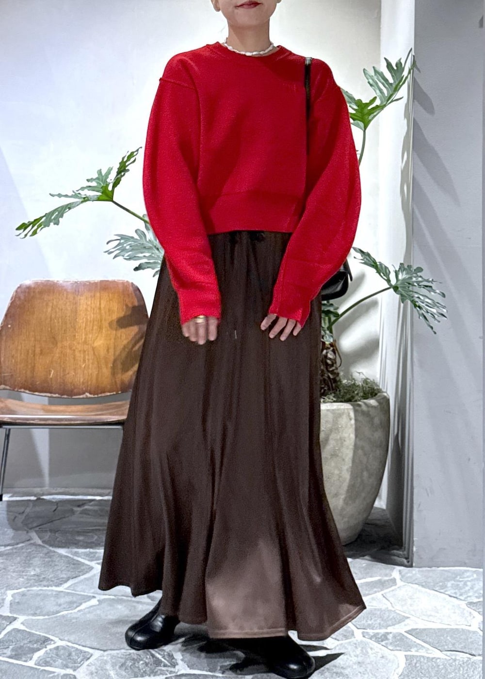 ブラック系のブーツ、ブラウン系のスカート、レッド系のニット/セーターを着用したレディースの秋コーディネートの8枚目の写真