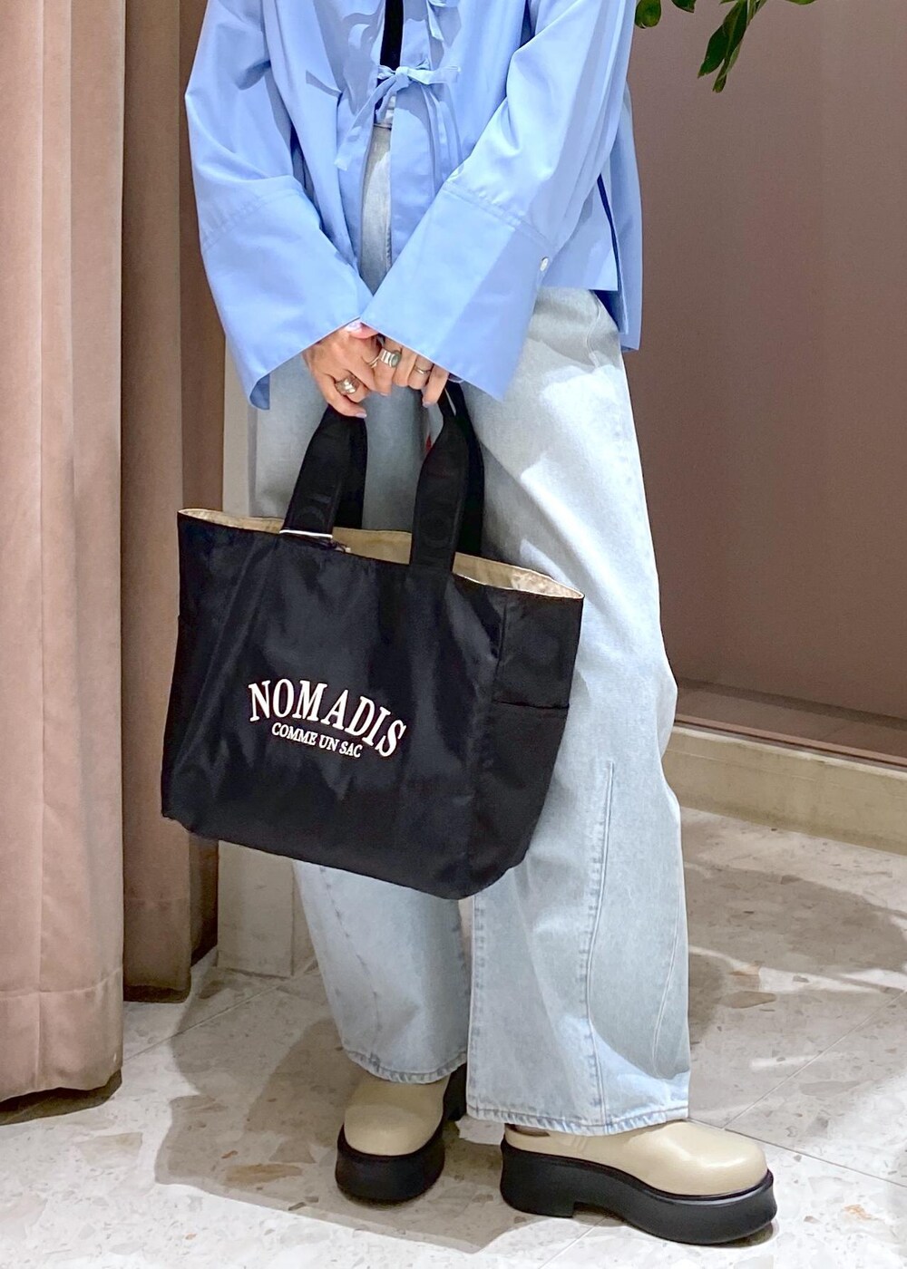 ブルー系のデニムパンツ、ブラック系のトートバッグ、ベージュ系のサンダルを着用したレディースの秋コーディネートの10枚目の写真