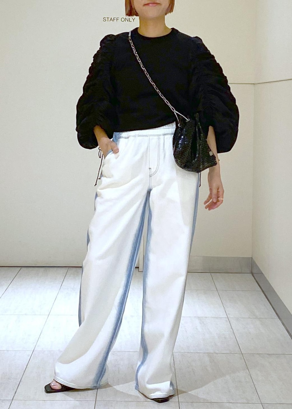 ブラック系のサンダル、ブラック系のTシャツ/カットソー、ブラック系のハンドバッグを着用したレディースの春コーディネートの2枚目の写真