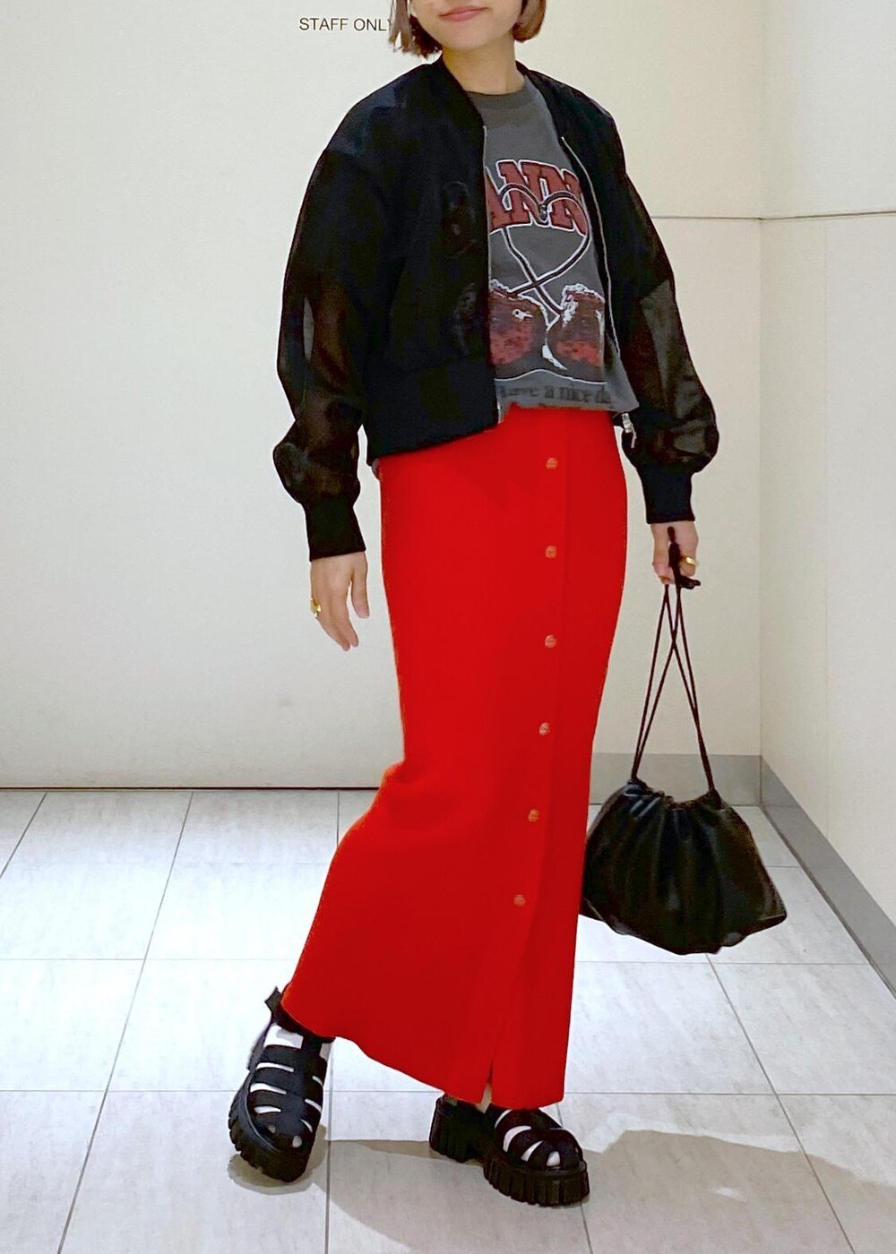 ブラック系のサンダル、ブラック系のショルダーバッグ、レッド系のスカートを着用したレディースの春コーディネートの7枚目の写真