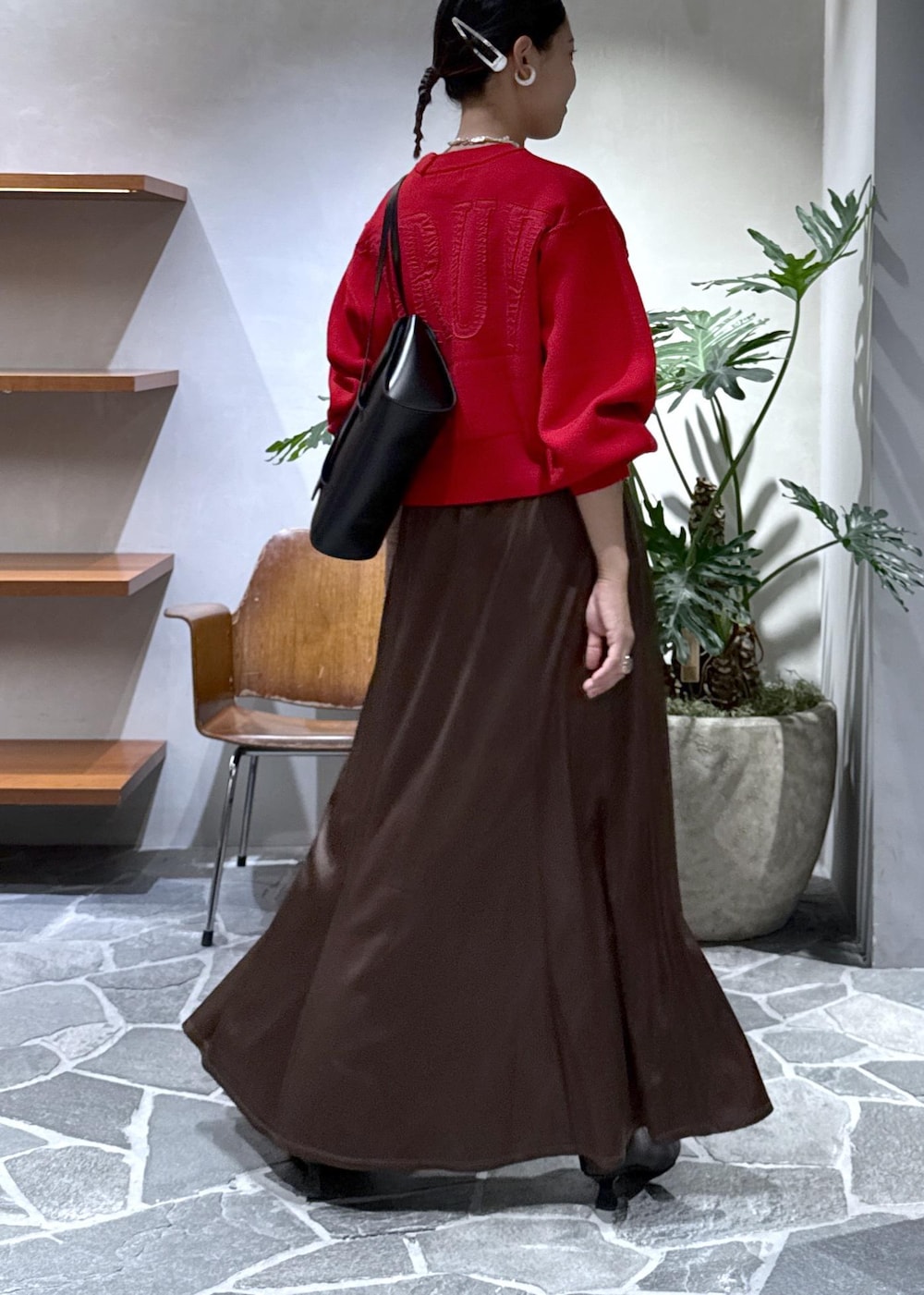 ブラック系のブーツ、ブラウン系のスカート、レッド系のニット/セーターを着用したレディースの秋コーディネートの4枚目の写真