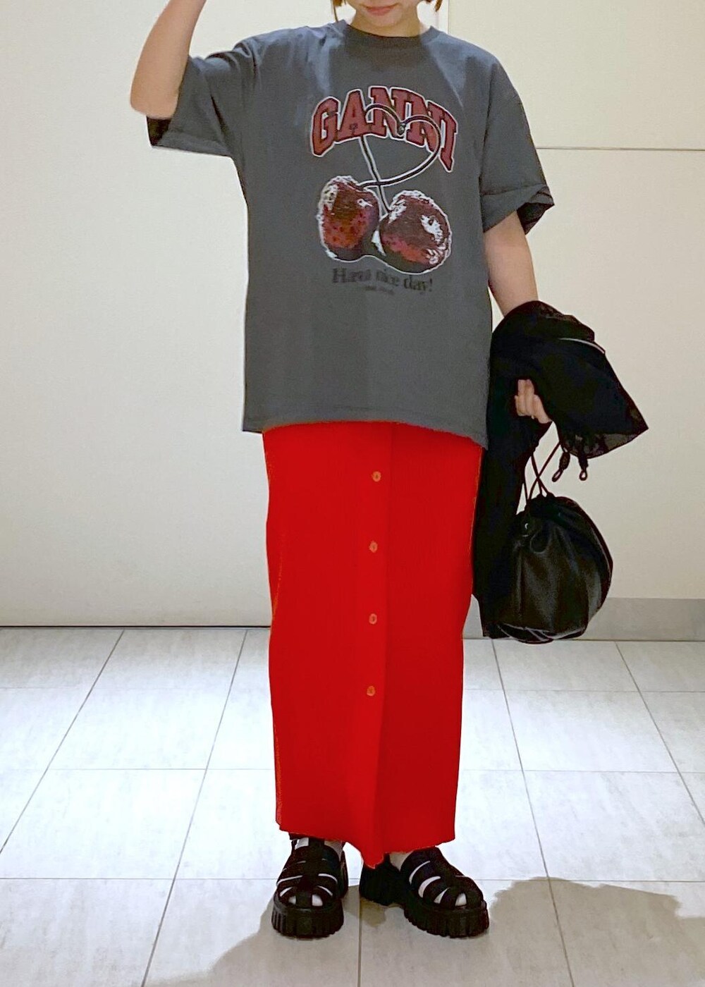 ブラック系のサンダル、ブラック系のショルダーバッグ、レッド系のスカートを着用したレディースの春コーディネートの10枚目の写真