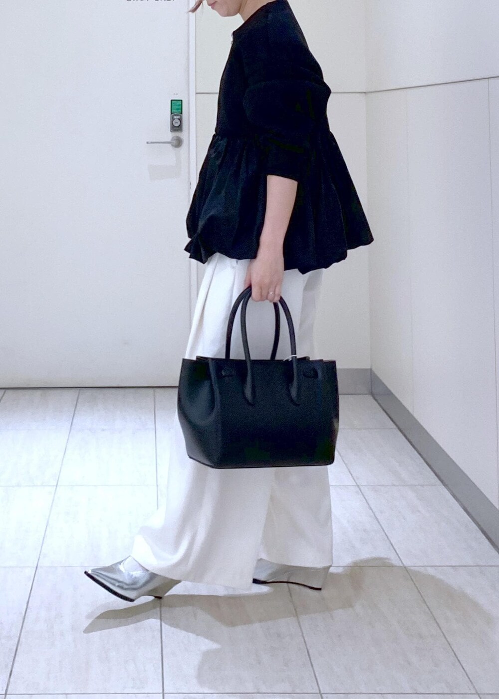 ホワイト系のその他パンツ、ブラック系のカーディガン/ボレロ、シルバー系のパンプスを着用したレディースの冬コーディネートの4枚目の写真