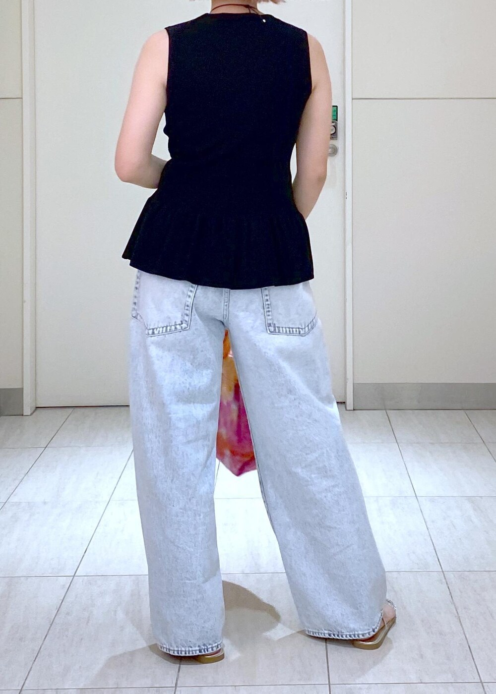 シルバー系のサンダル、ブラック系のニット/セーター、ブルー系のデニムパンツを着用したレディースの春コーディネートの5枚目の写真