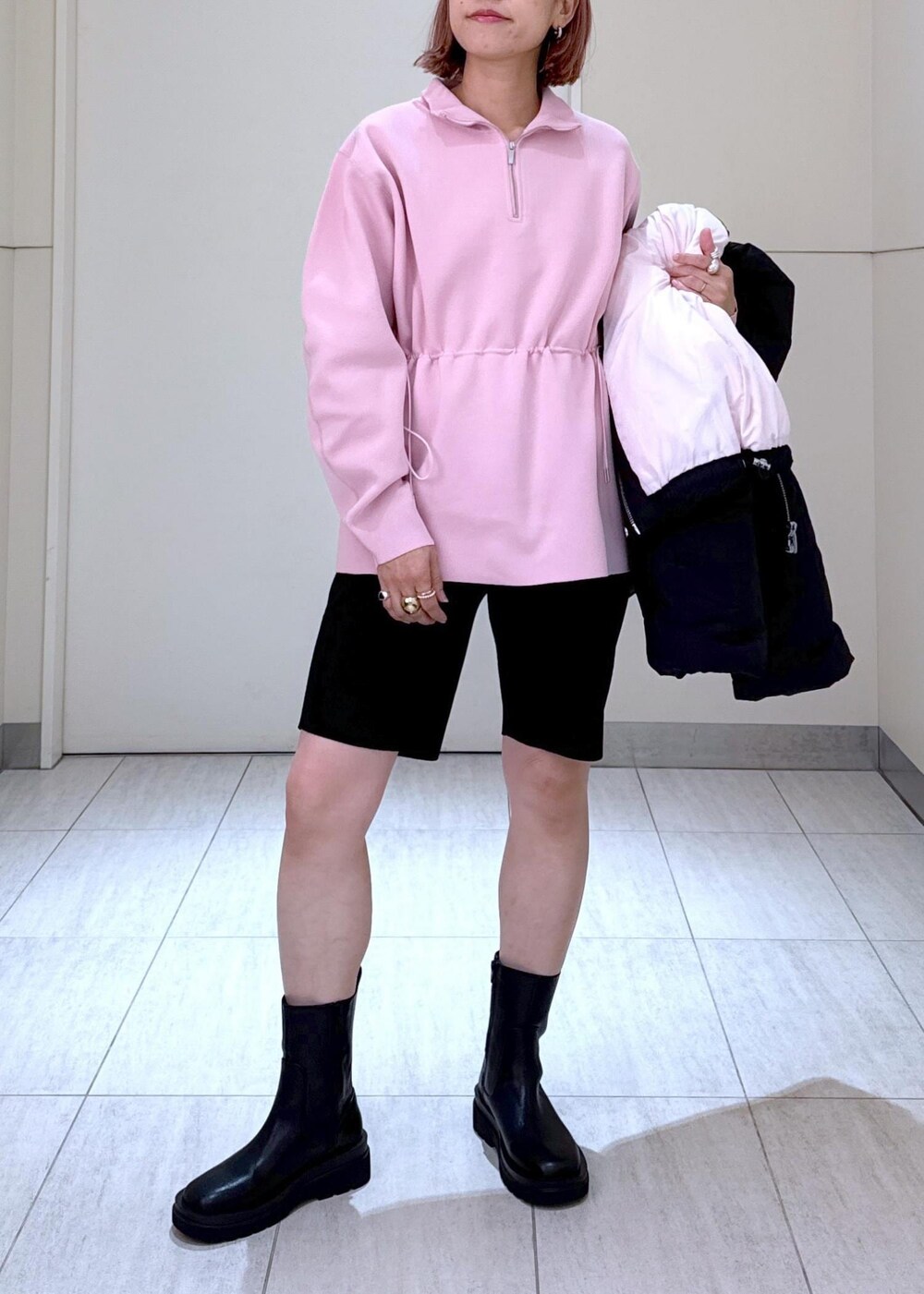 ブラック系のブーツ、ピンク系のその他トップス、ブラック系のボストンバッグを着用したレディースの秋コーディネートの10枚目の写真