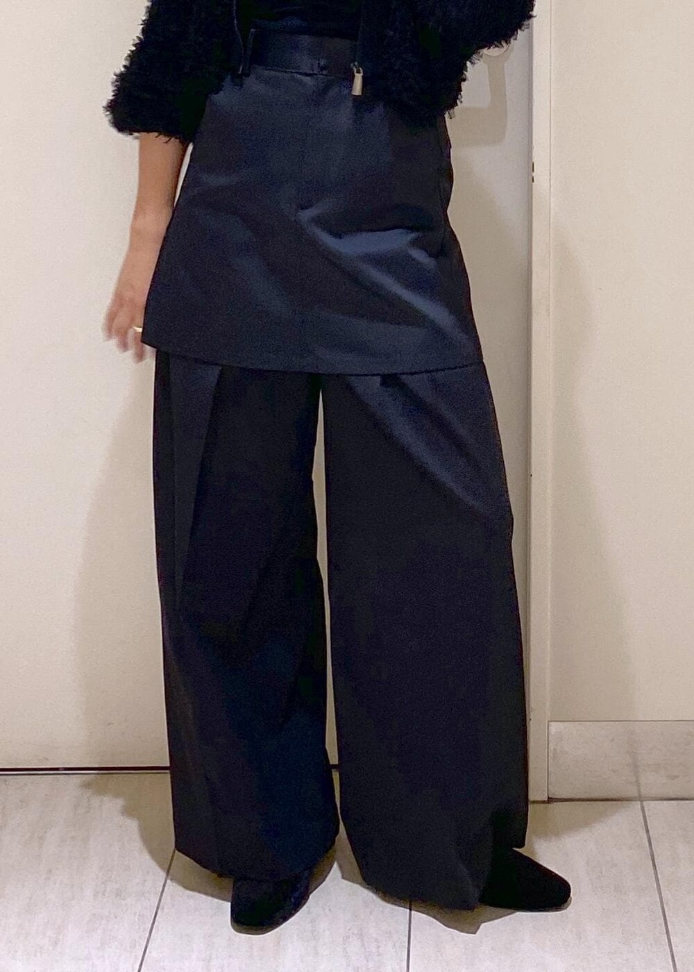 ブラック系のパンプス、ブラック系のスラックス、ブラック系のスカートを着用したレディースの秋コーディネートの7枚目の写真