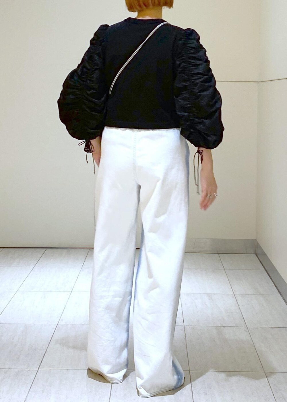 ブラック系のサンダル、ブラック系のTシャツ/カットソー、ブラック系のハンドバッグを着用したレディースの春コーディネートの5枚目の写真