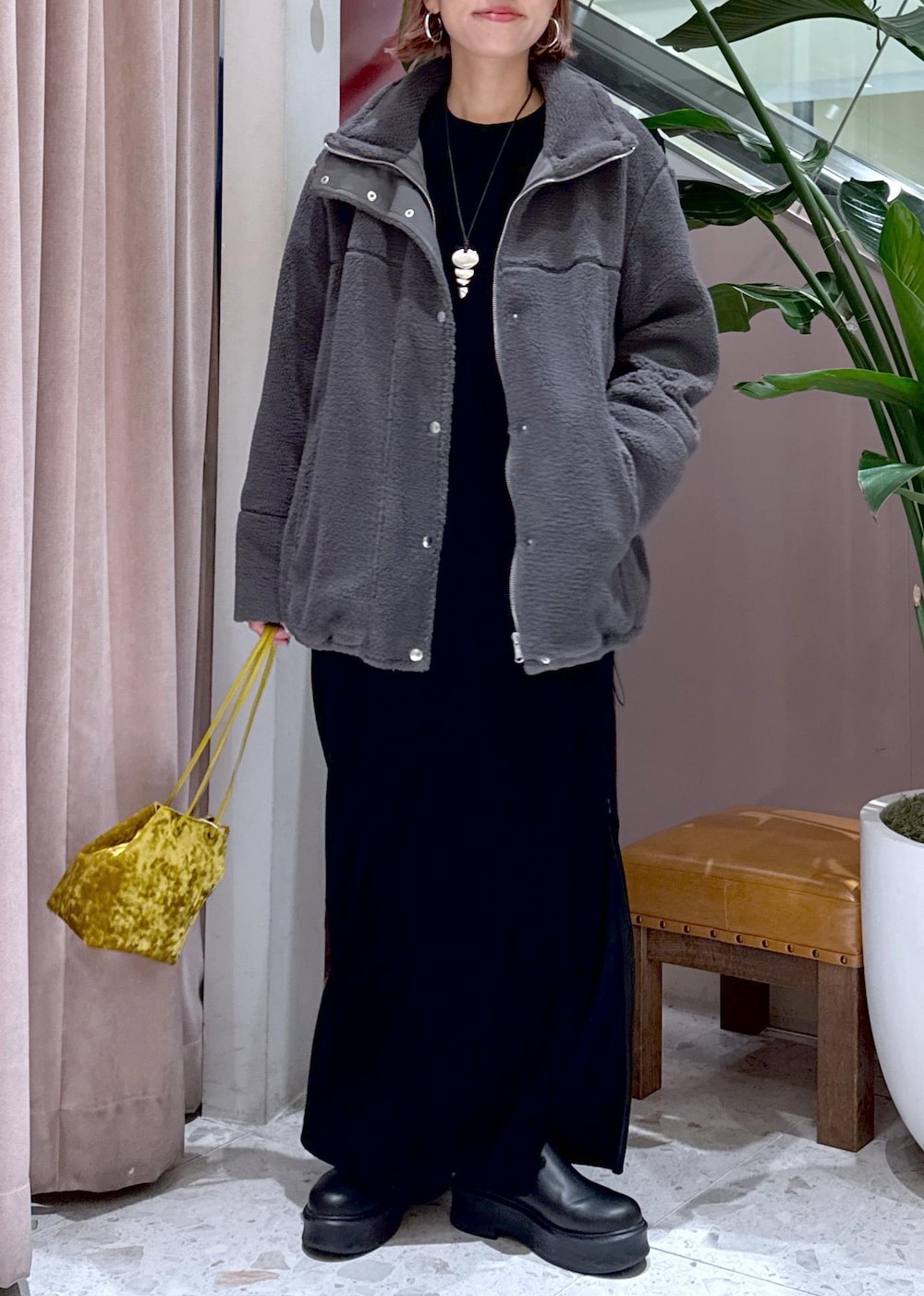 ブラック系のサンダル、グレー系のブルゾン、イエロー系のハンドバッグを着用したレディースの秋コーディネートの2枚目の写真