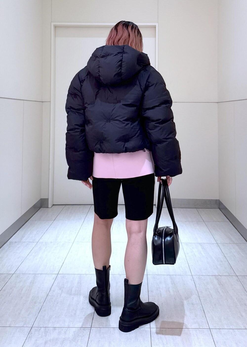 ブラック系のブーツ、ピンク系のその他トップス、ブラック系のボストンバッグを着用したレディースの秋コーディネートの7枚目の写真