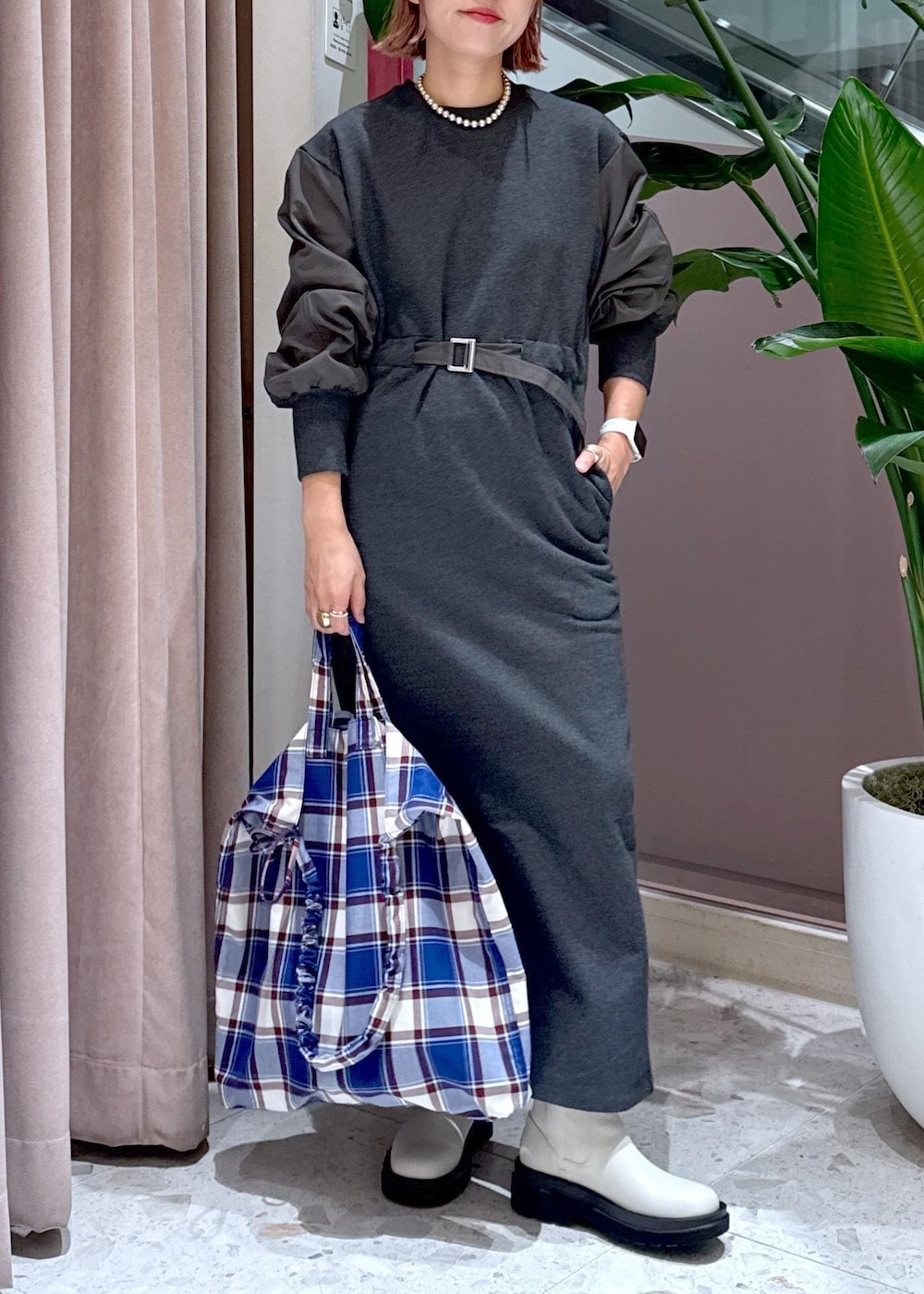 ホワイト系のブーツ、ブルー系のトートバッグ、グレー系のワンピースを着用したレディースの秋コーディネートの2枚目の写真