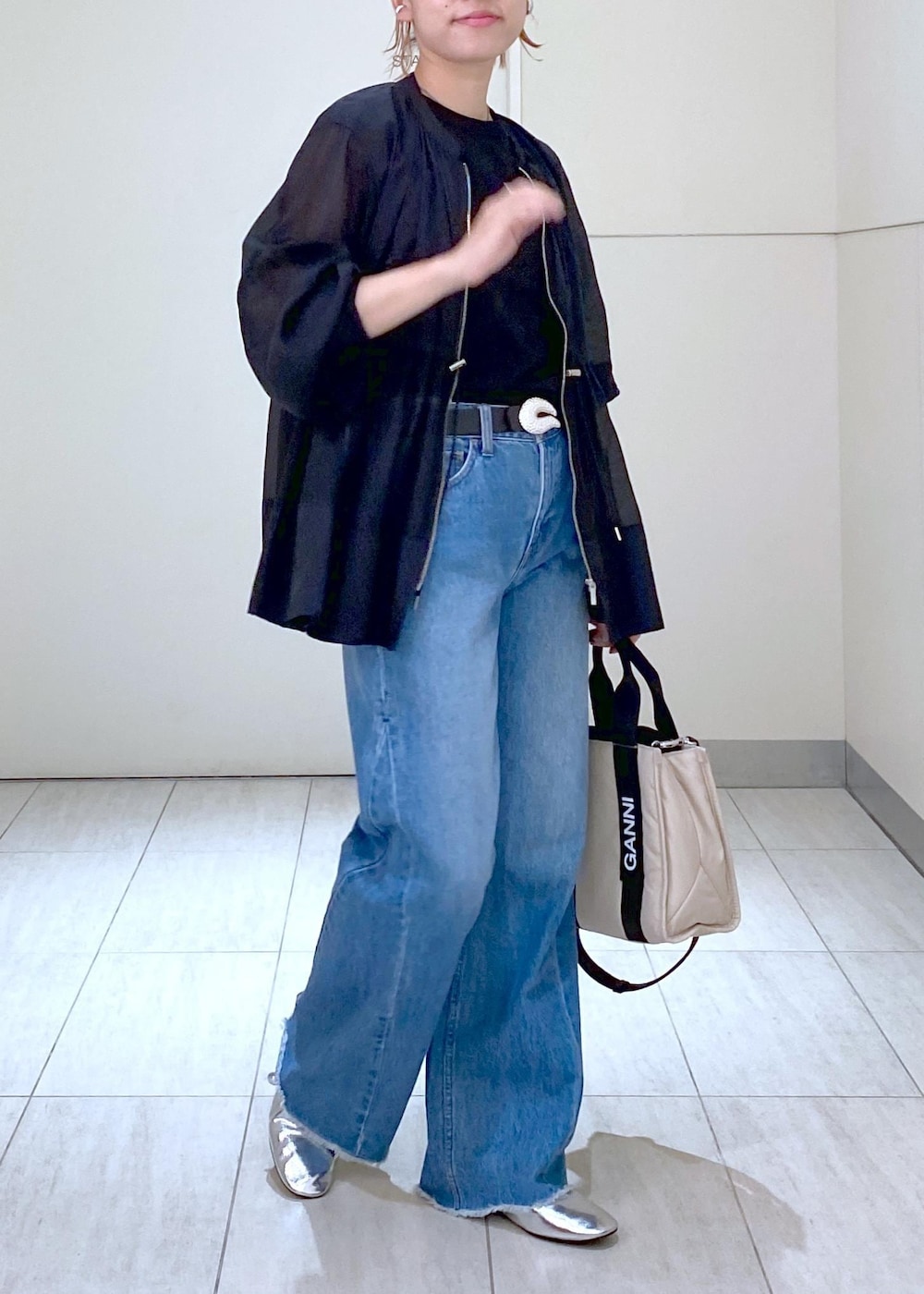 ブルー系のデニムパンツ、シルバー系のバレエシューズ、ブラック系のTシャツ/カットソーを着用したレディースの夏コーディネートの2枚目の写真