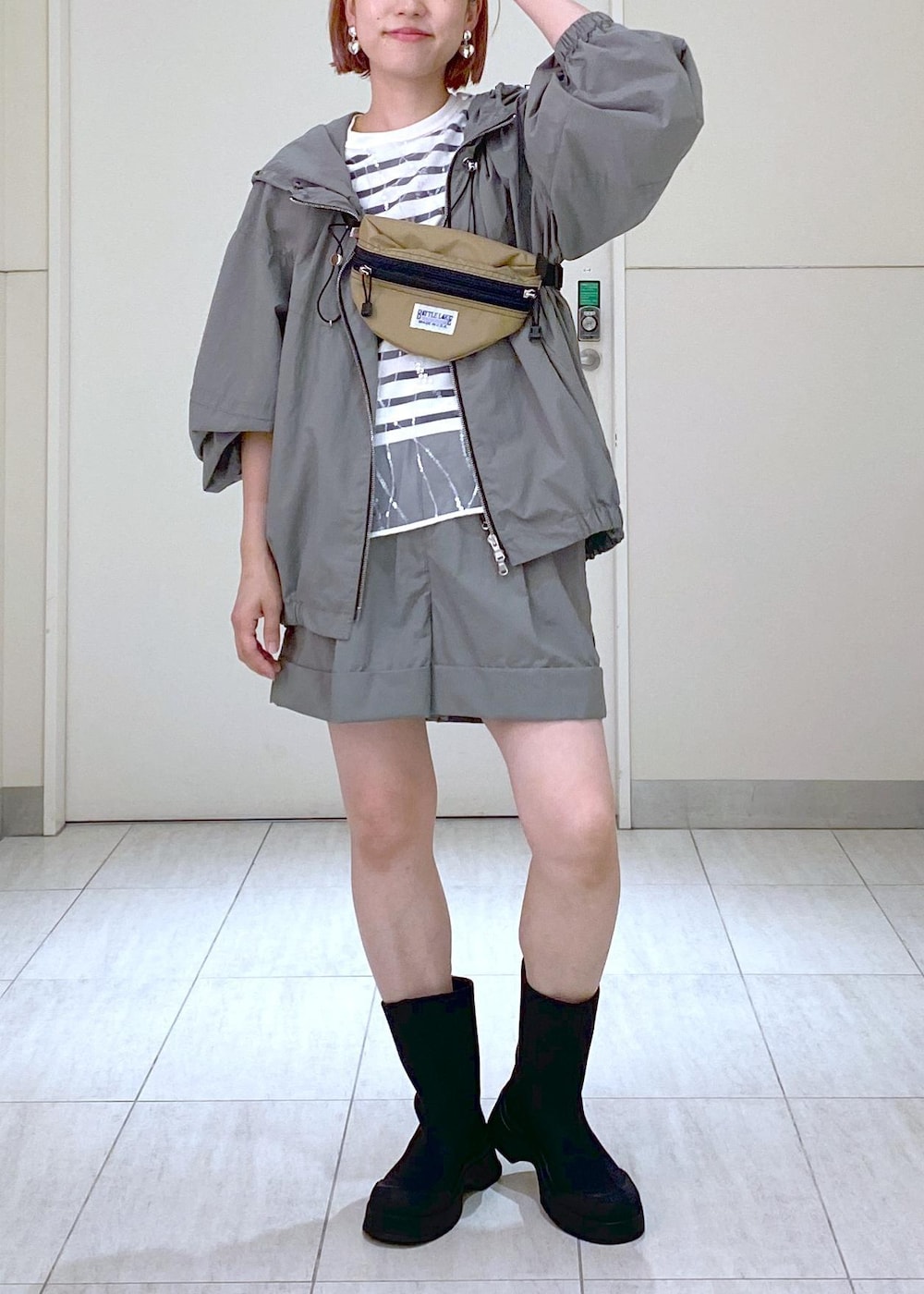 ホワイト系のニット/セーター、ベージュ系のボディバッグ/ウエストポーチ、グリーン系のその他アウターを着用したレディースの夏コーディネートの3枚目の写真