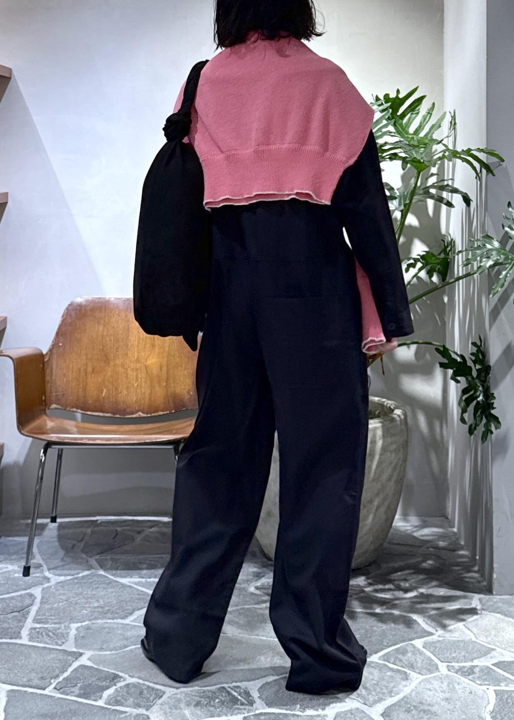 ブラック系のショルダーバッグ、ブラック系のサンダル、ピンク系のニット/セーターを着用したレディースの春コーディネートの5枚目の写真