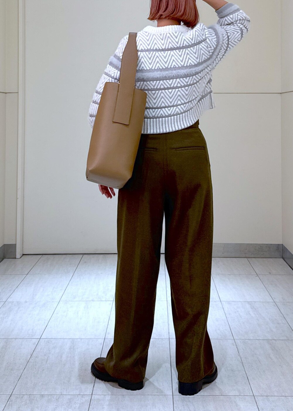ホワイト系のカーディガン/ボレロ、グリーン系のスラックス、ブラウン系のハンドバッグを着用したレディースの秋コーディネートの10枚目の写真