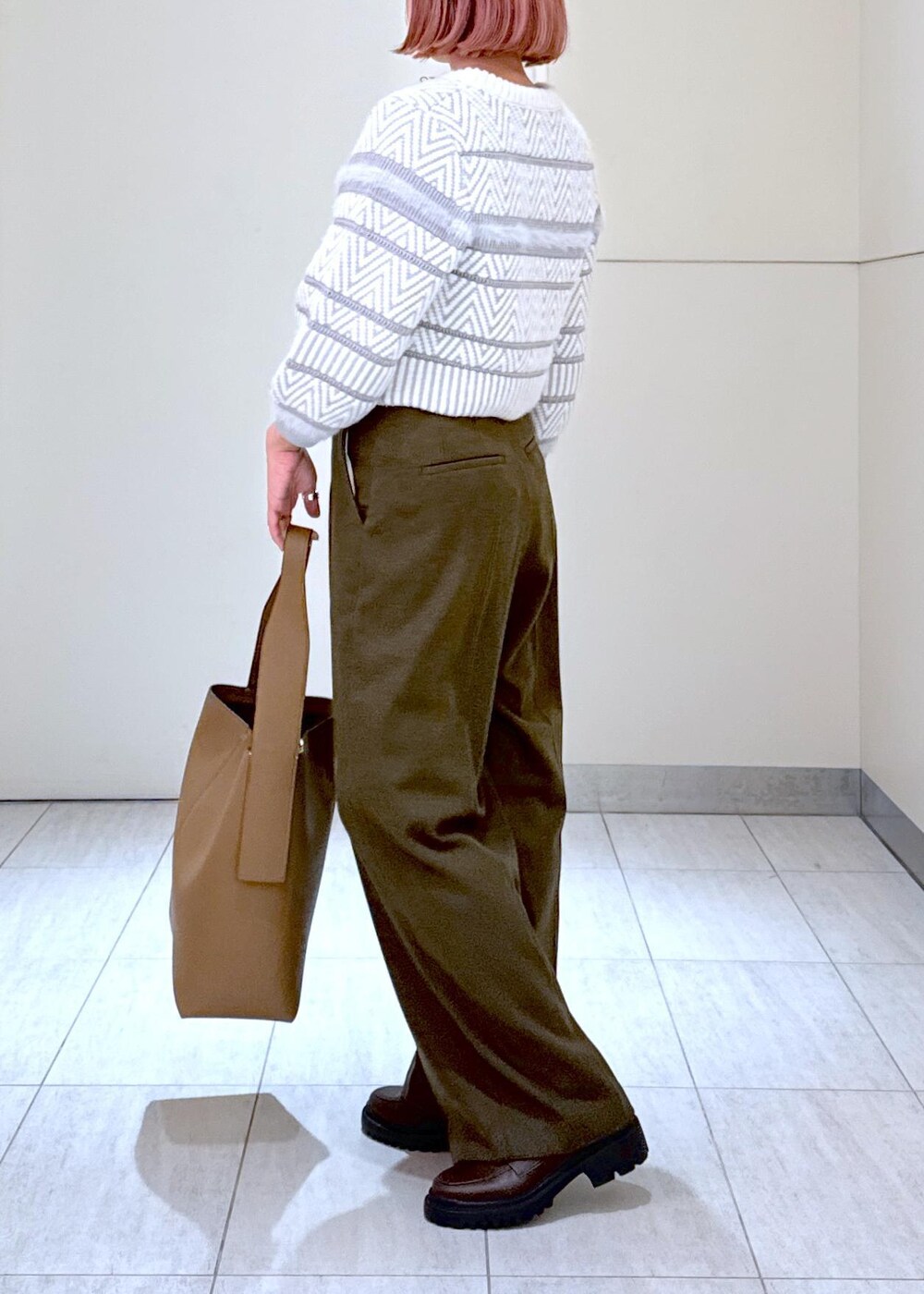 ホワイト系のカーディガン/ボレロ、グリーン系のスラックス、ブラウン系のハンドバッグを着用したレディースの秋コーディネートの5枚目の写真