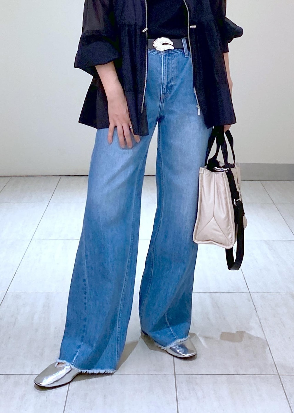 ブルー系のデニムパンツ、シルバー系のバレエシューズ、ブラック系のTシャツ/カットソーを着用したレディースの夏コーディネートの6枚目の写真