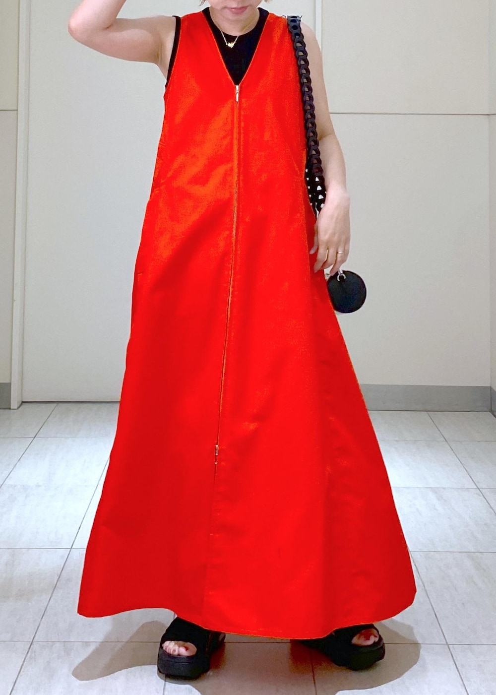 ブラック系のサンダル、ブラック系のドラムバッグ、レッド系のワンピースを着用したレディースの夏コーディネートの8枚目の写真