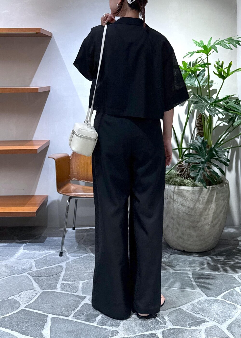 ホワイト系のショルダーバッグ、ブラック系のキャミソール、ブラック系のスラックスを着用したレディースの夏コーディネートの7枚目の写真