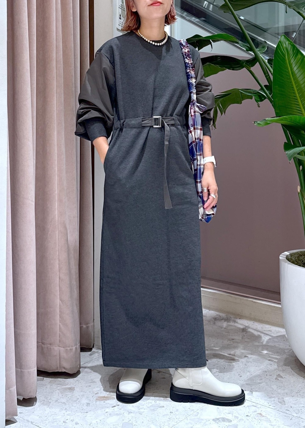 ホワイト系のブーツ、ブルー系のトートバッグ、グレー系のワンピースを着用したレディースの秋コーディネートの3枚目の写真