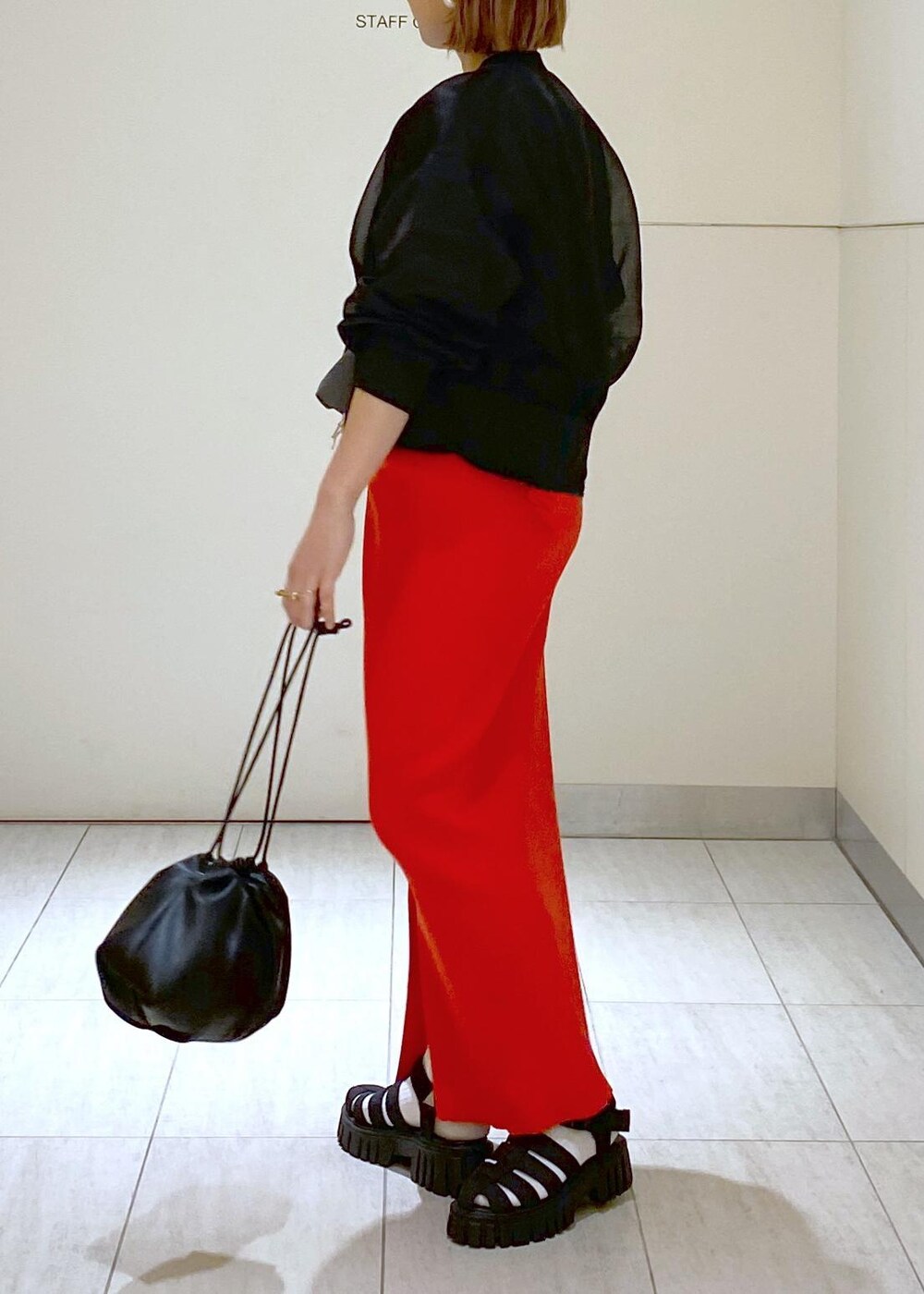 ブラック系のサンダル、ブラック系のショルダーバッグ、レッド系のスカートを着用したレディースの春コーディネートの4枚目の写真