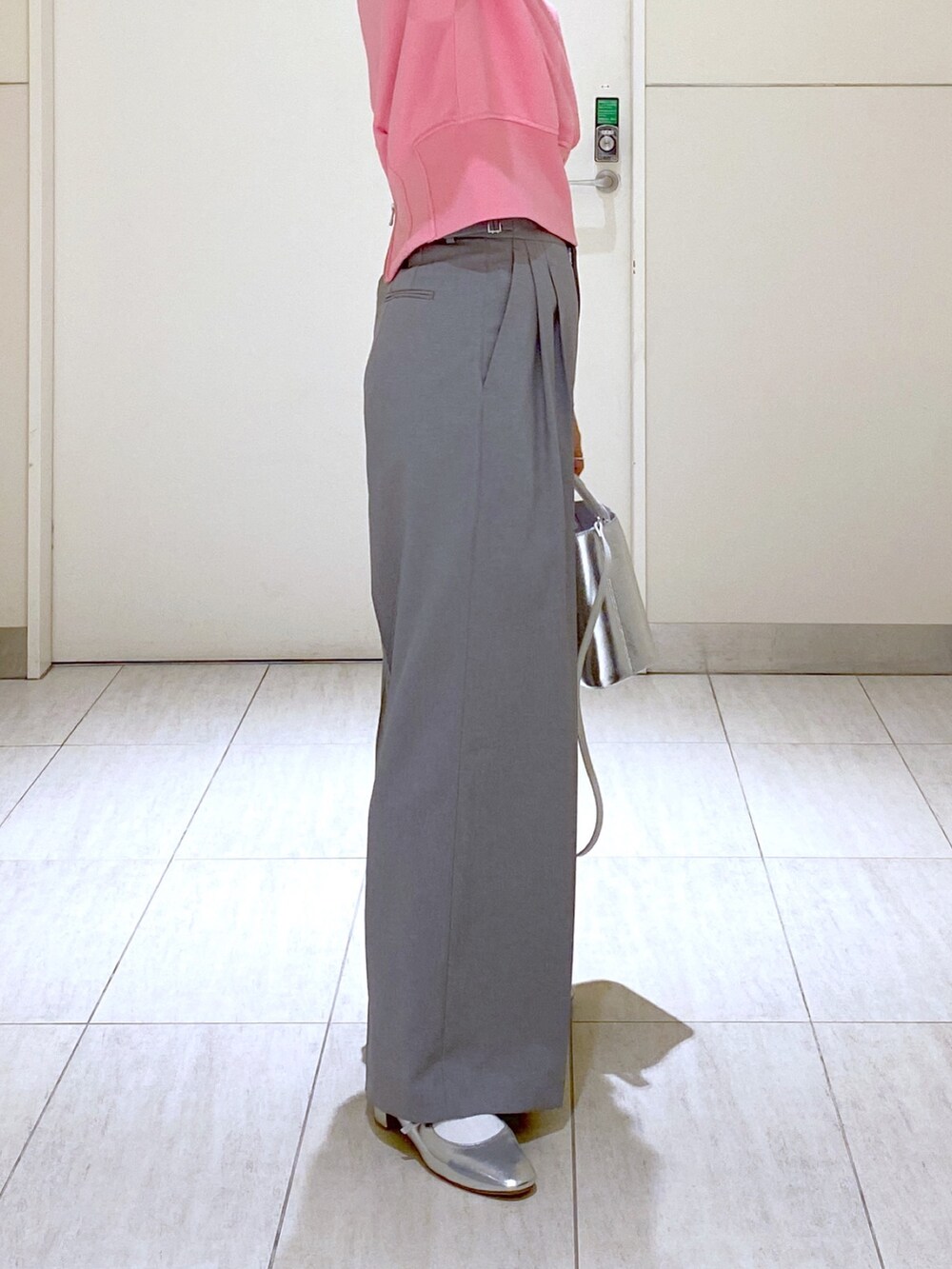 ピンク系のスウェット、グレー系のスラックス、シルバー系のショルダーバッグを着用したレディースの冬コーディネートの5枚目の写真