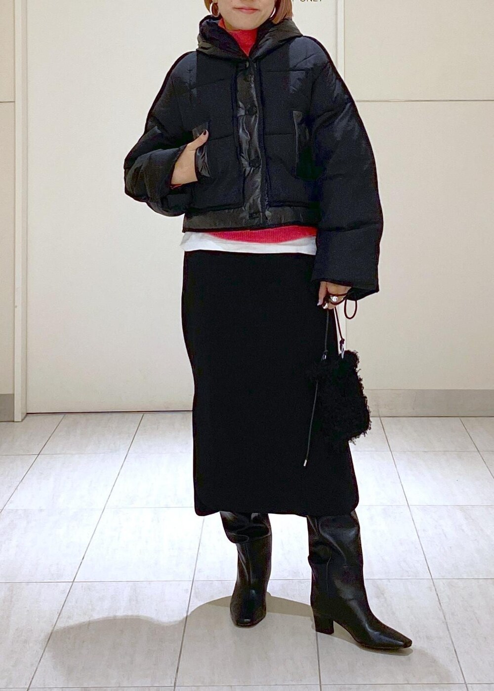 ピンク系のニット/セーター、ブラック系のブーツ、ブラック系のショルダーバッグを着用したレディースの秋コーディネートの5枚目の写真