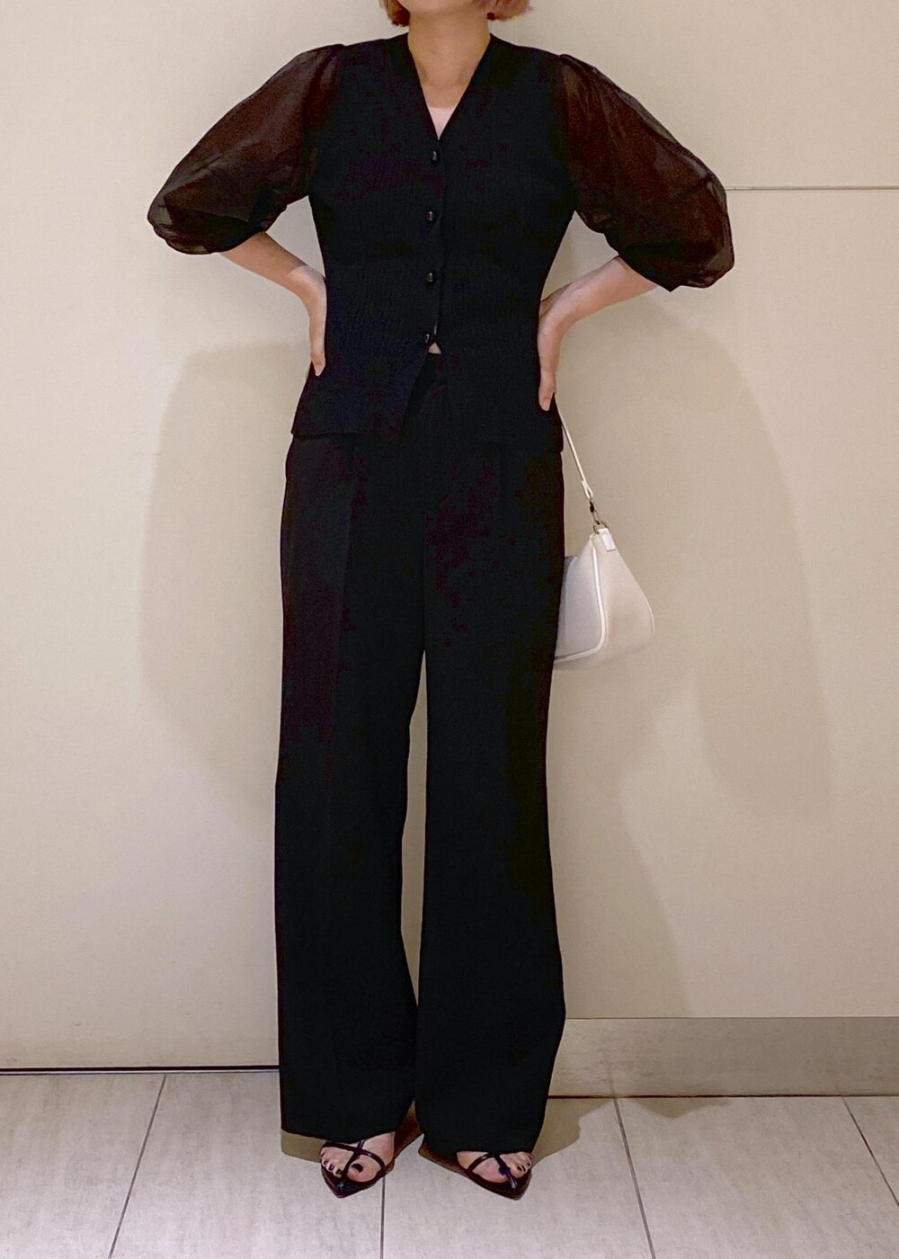 ブラック系のサンダル、ホワイト系のショルダーバッグ、ブラック系のスラックスを着用したレディースの夏コーディネートの2枚目の写真