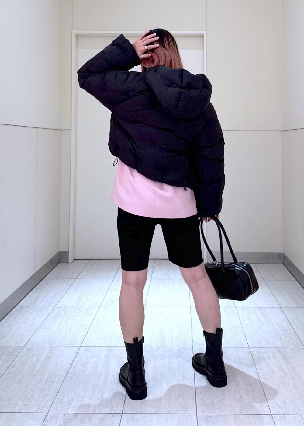 ブラック系のブーツ、ピンク系のその他トップス、ブラック系のボストンバッグを着用したレディースの秋コーディネートの6枚目の写真