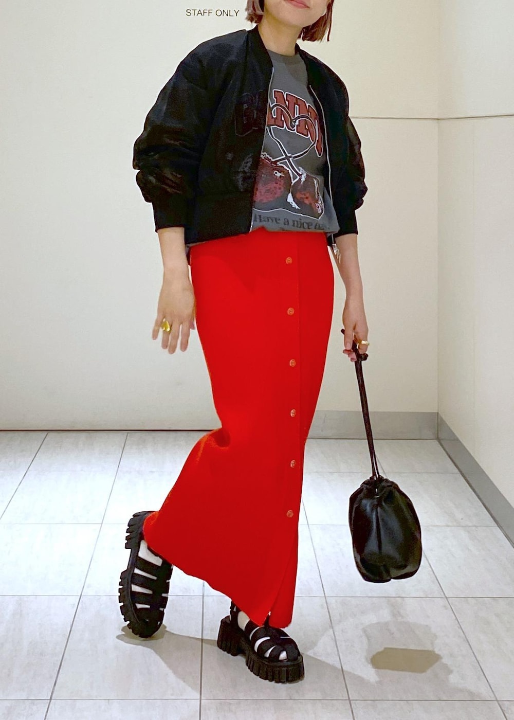 ブラック系のサンダル、ブラック系のショルダーバッグ、レッド系のスカートを着用したレディースの春コーディネートの3枚目の写真