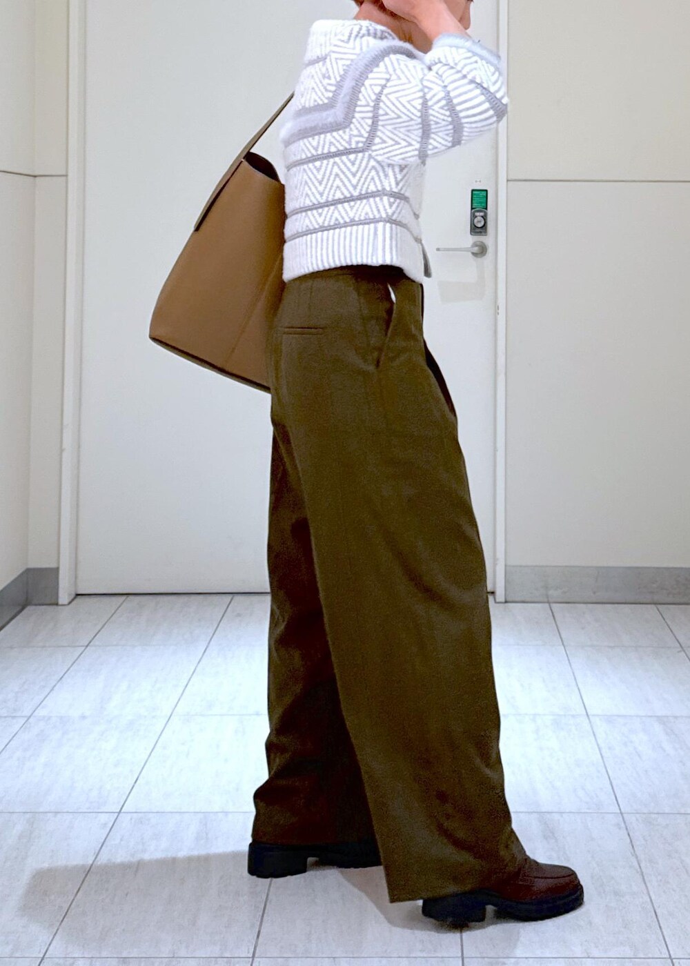 ホワイト系のカーディガン/ボレロ、グリーン系のスラックス、ブラウン系のハンドバッグを着用したレディースの秋コーディネートの8枚目の写真