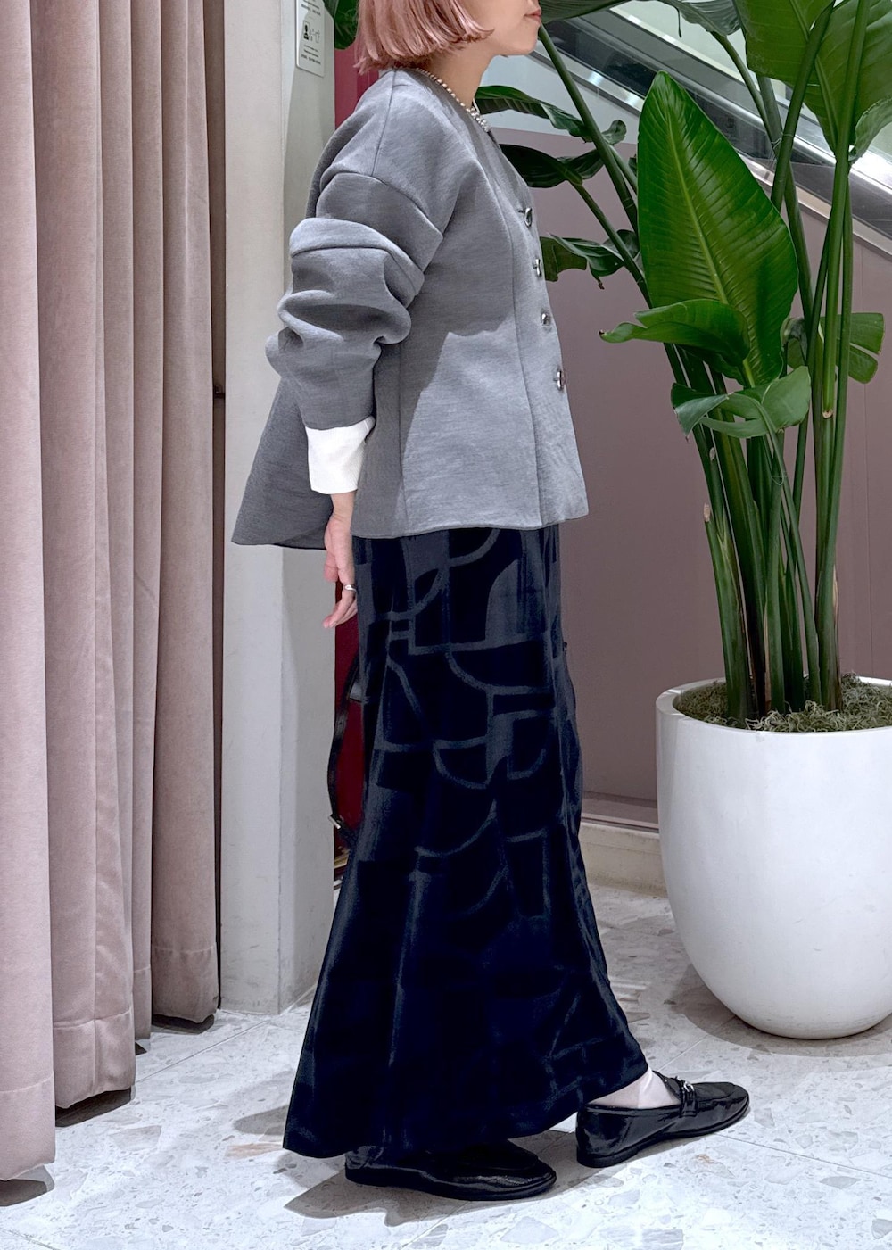 ブラック系のローファー、ブラック系のスカート、グレー系のカーディガン/ボレロを着用したレディースの秋コーディネートの8枚目の写真