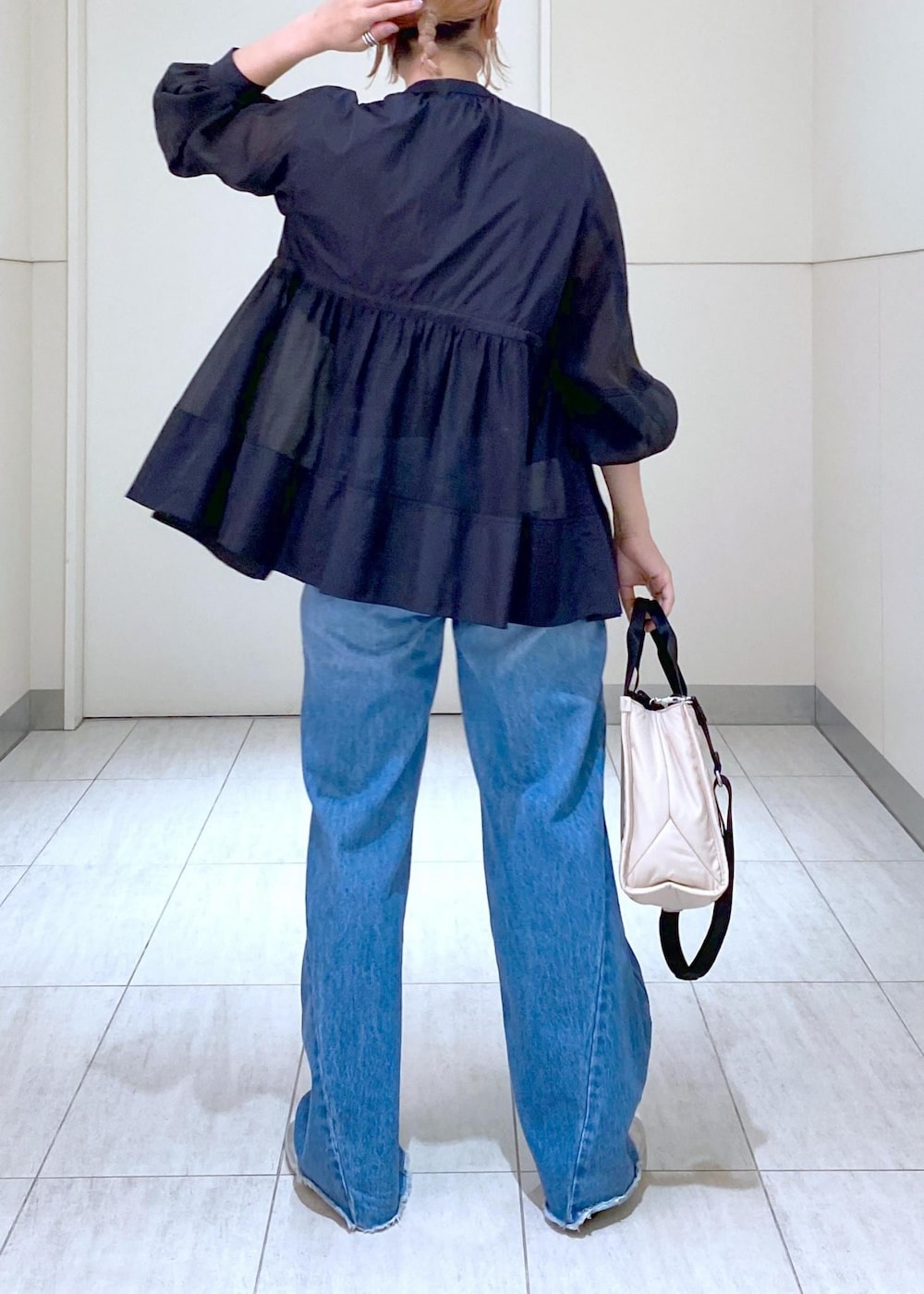 ブルー系のデニムパンツ、シルバー系のバレエシューズ、ブラック系のTシャツ/カットソーを着用したレディースの夏コーディネートの5枚目の写真