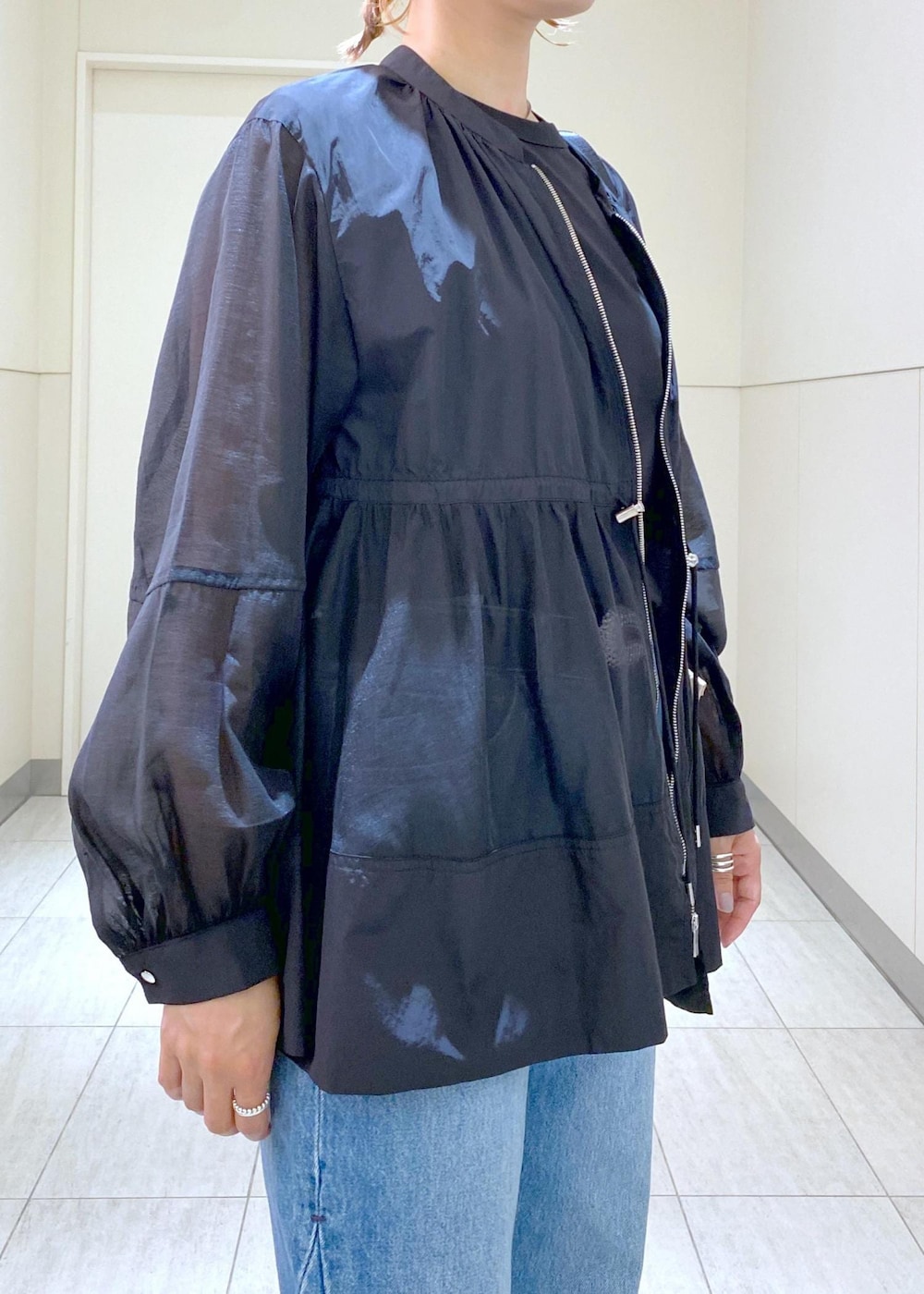 ブルー系のデニムパンツ、シルバー系のバレエシューズ、ブラック系のTシャツ/カットソーを着用したレディースの夏コーディネートの7枚目の写真