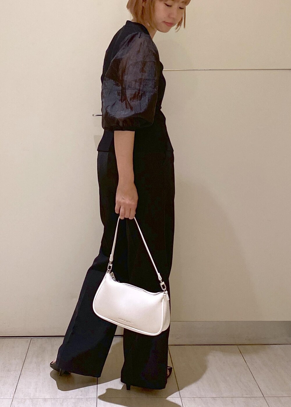 ブラック系のサンダル、ホワイト系のショルダーバッグ、ブラック系のスラックスを着用したレディースの夏コーディネートの6枚目の写真