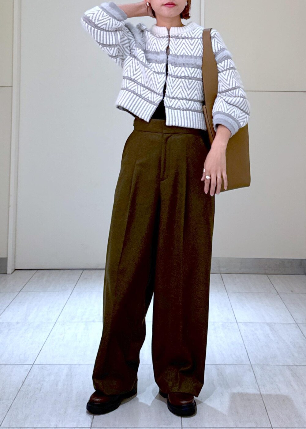 ホワイト系のカーディガン/ボレロ、グリーン系のスラックス、ブラウン系のハンドバッグを着用したレディースの秋コーディネートの4枚目の写真