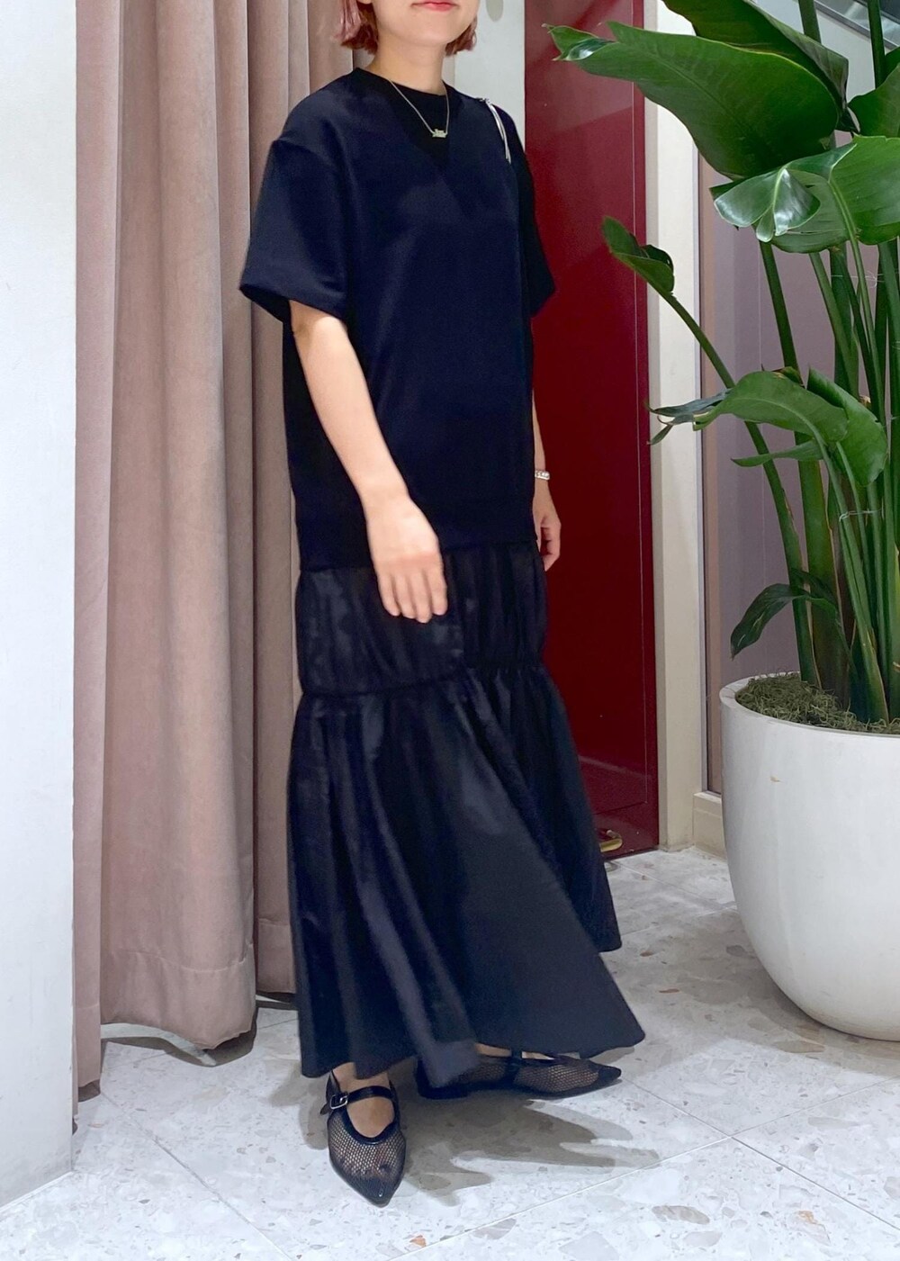 ブラック系のハンドバッグ、ブラック系のパンプス、ブラック系のワンピースを着用したレディースの夏コーディネートの5枚目の写真