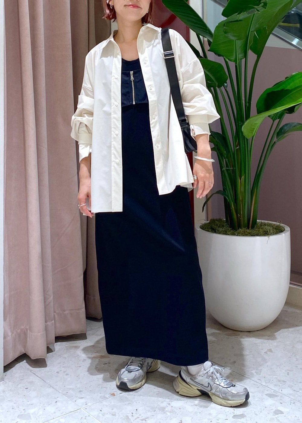 ブラック系のショルダーバッグ、ブラック系のワンピース、ホワイト系のシャツ/ブラウスを着用したレディースの春コーディネートの2枚目の写真