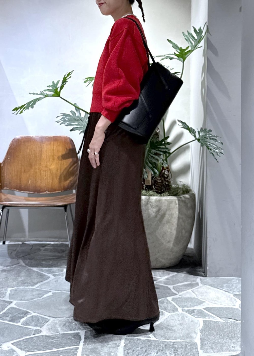 ブラック系のブーツ、ブラウン系のスカート、レッド系のニット/セーターを着用したレディースの秋コーディネートの6枚目の写真