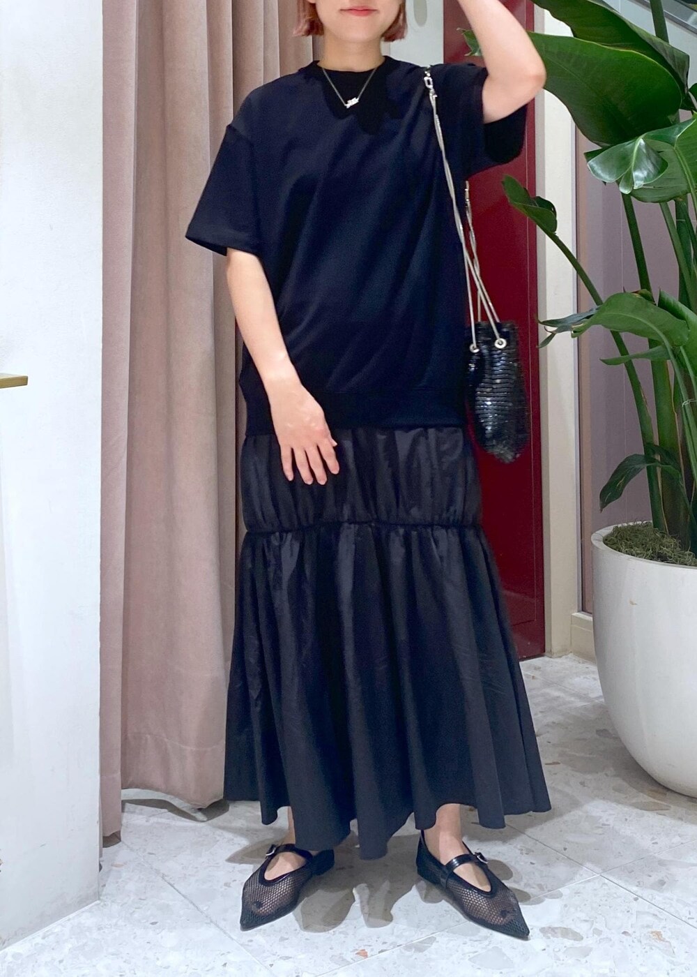 ブラック系のハンドバッグ、ブラック系のパンプス、ブラック系のワンピースを着用したレディースの夏コーディネートの3枚目の写真