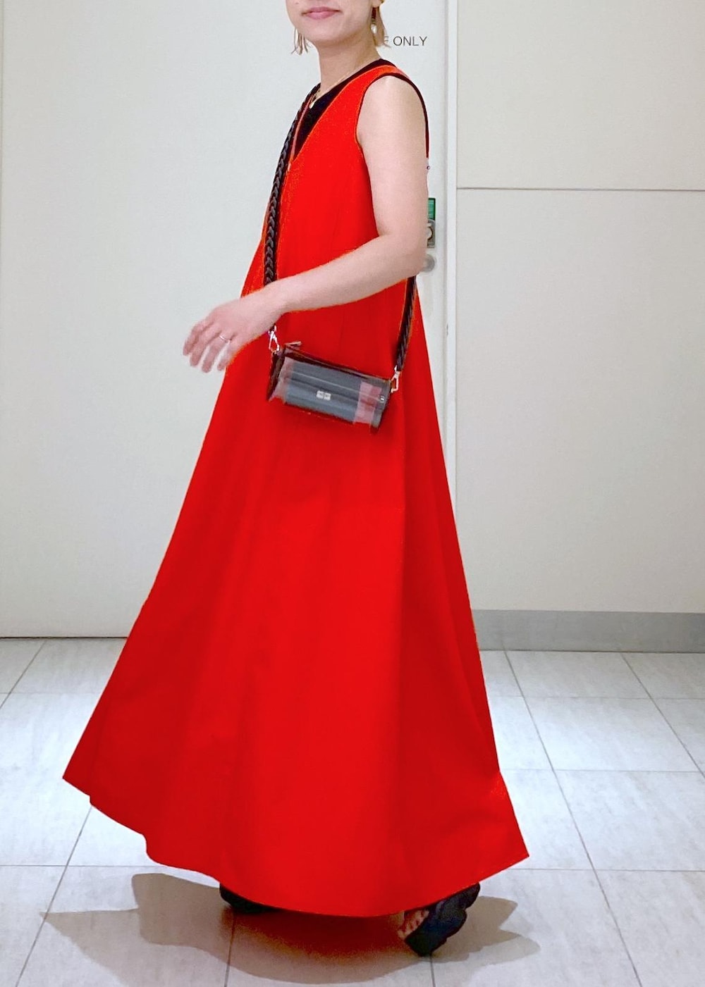 ブラック系のサンダル、ブラック系のドラムバッグ、レッド系のワンピースを着用したレディースの夏コーディネートの5枚目の写真