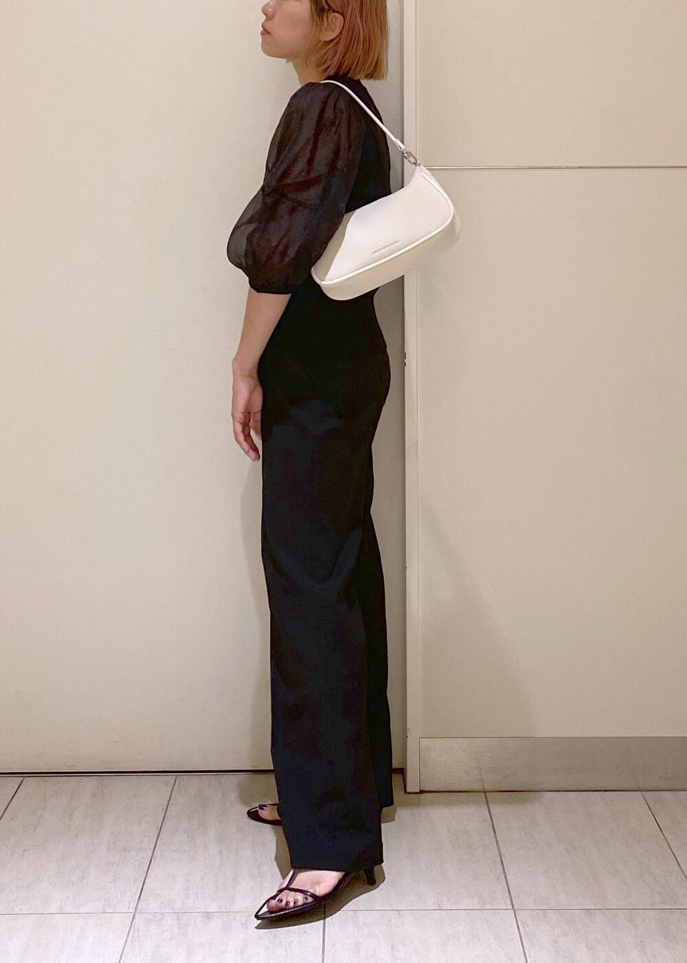 ブラック系のサンダル、ホワイト系のショルダーバッグ、ブラック系のスラックスを着用したレディースの夏コーディネートの5枚目の写真