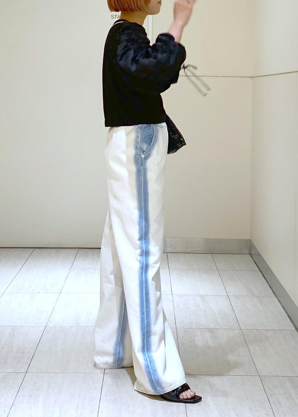 ブラック系のサンダル、ブラック系のTシャツ/カットソー、ブラック系のハンドバッグを着用したレディースの春コーディネートの6枚目の写真