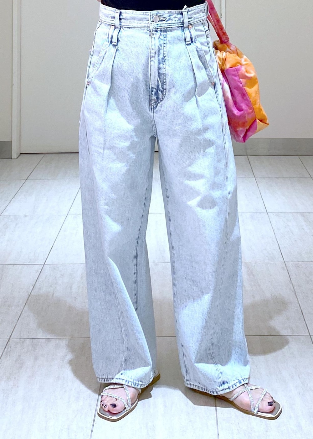 シルバー系のサンダル、ブラック系のニット/セーター、ブルー系のデニムパンツを着用したレディースの春コーディネートの8枚目の写真