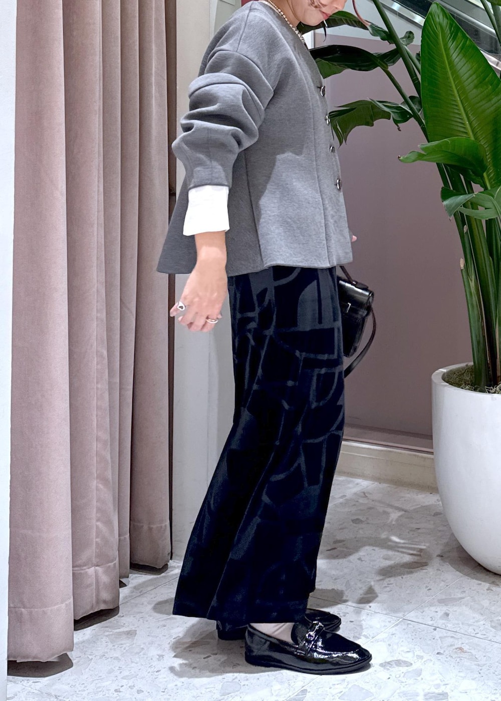 ブラック系のローファー、ブラック系のスカート、グレー系のカーディガン/ボレロを着用したレディースの秋コーディネートの7枚目の写真